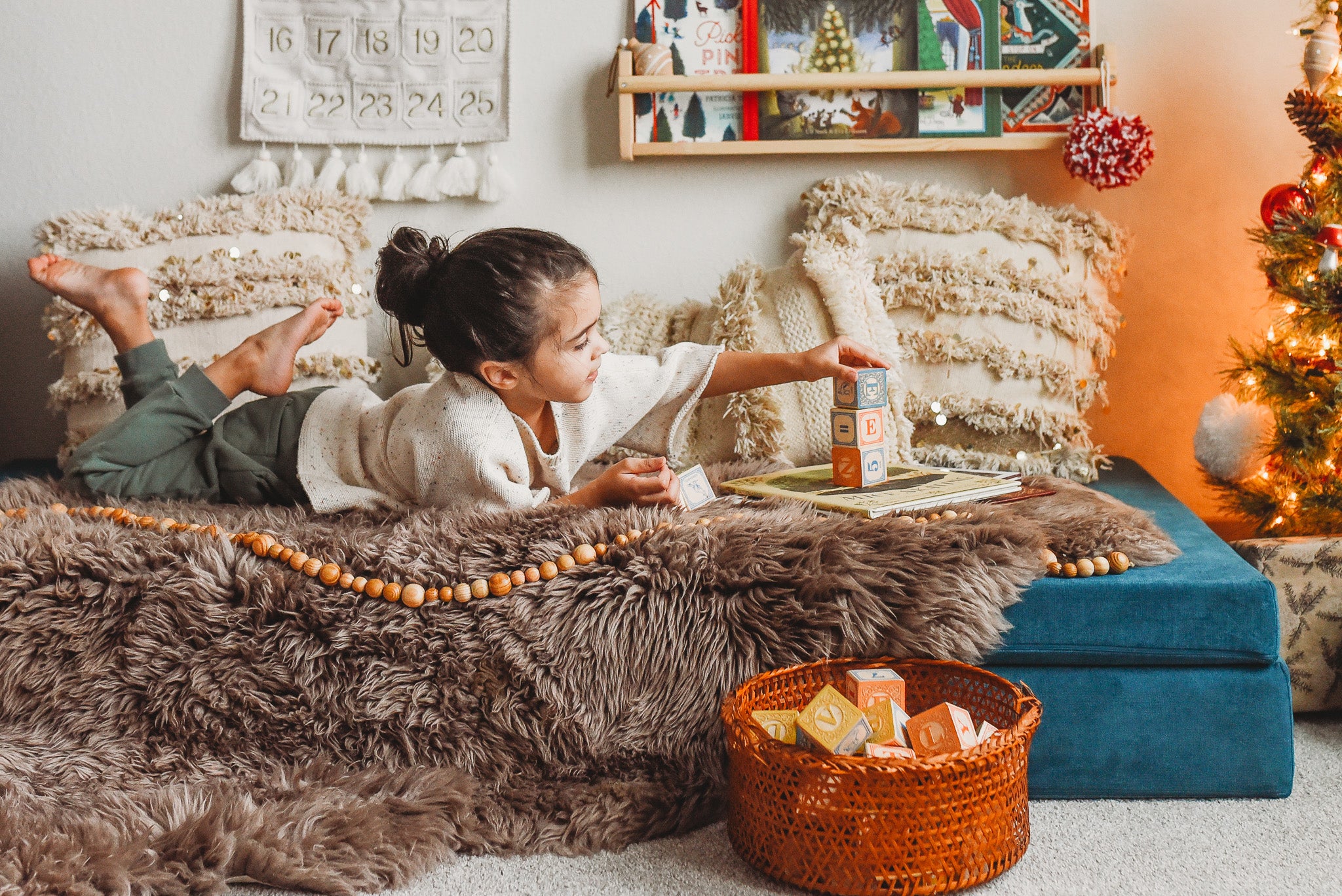 A child in Christmas pajamas playing with Magic Wood Eco Blocks Tree Branch Blocks 