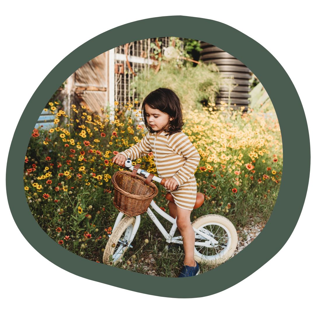 A child sitting on a white classic Banwood strider bike