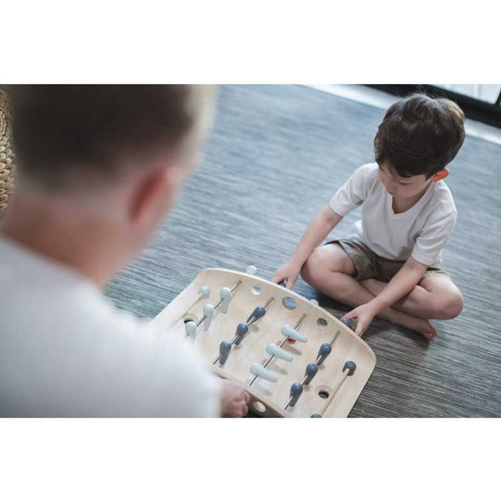 Child playing with PlanToys - Wooden Tabletop Soccer Game