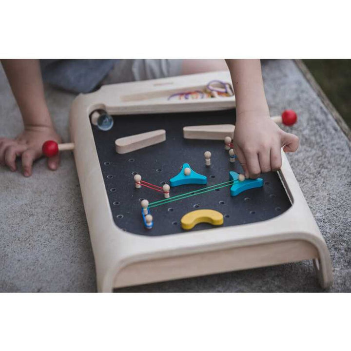 Child playing with PlanToys - Wooden Pinball Game Set