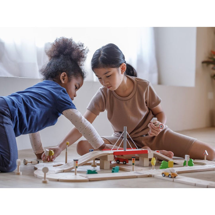 2 children playing with PlanToys - Wooden Road System Play Set