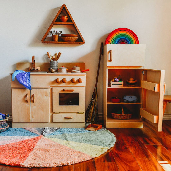 Bella Luna Wooden Kitchen and Refrigerator with door open in playroom on wooden floor