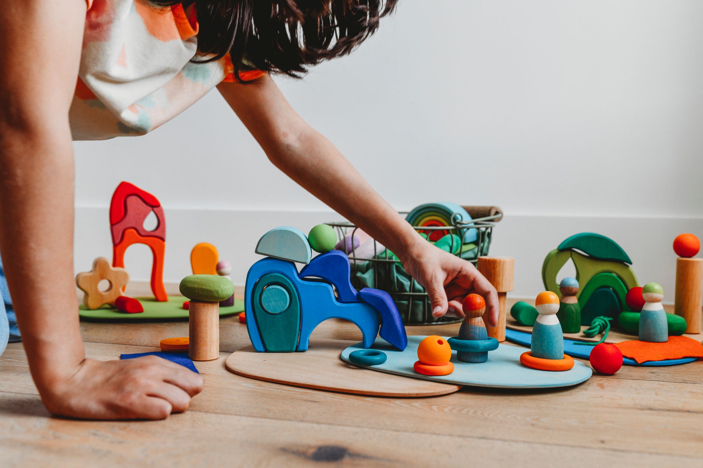 Child playing with Grimm's wooden pieces