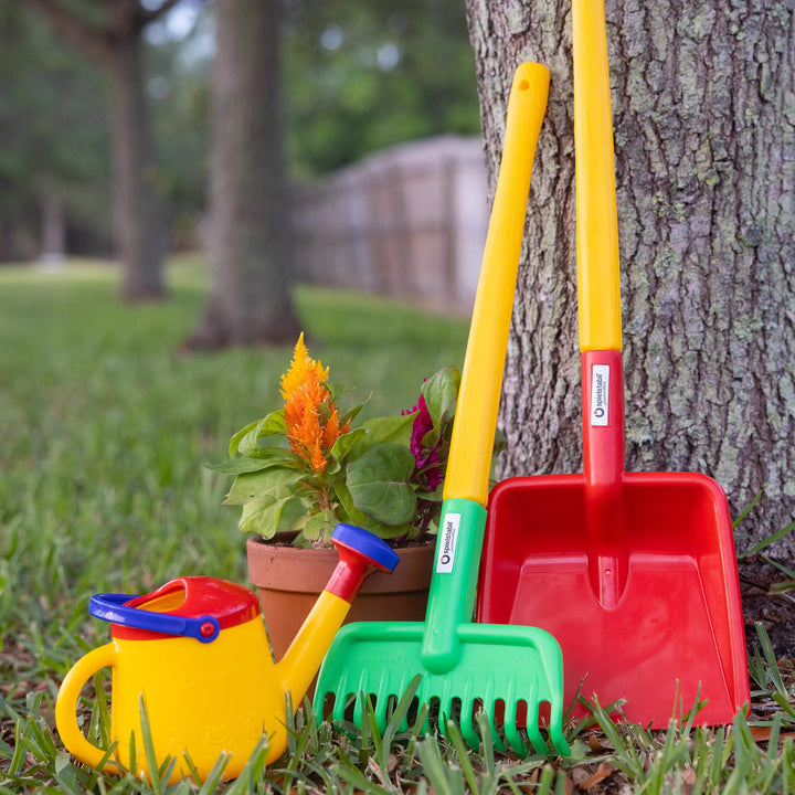 Spielstabil Long Handled Flat Shovel and Garden Rake leaning against a tree with a flower pot and Watering Can