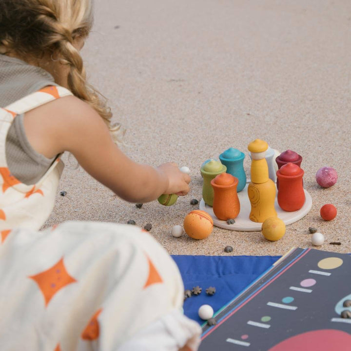 Child playing with Grapat Dear Universe wooden ball set