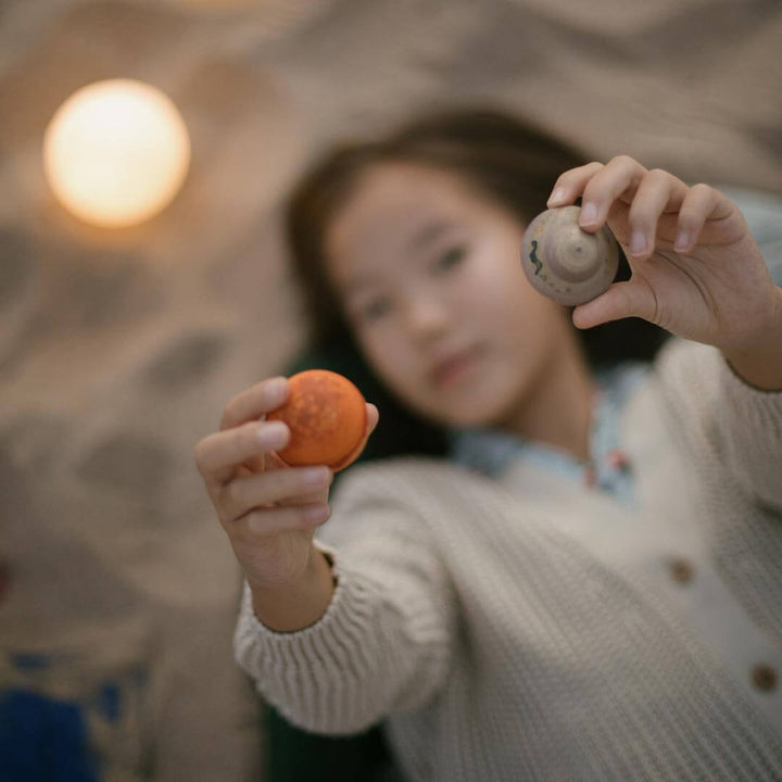 Girl holding Grapat Dear Universe wooden ball set