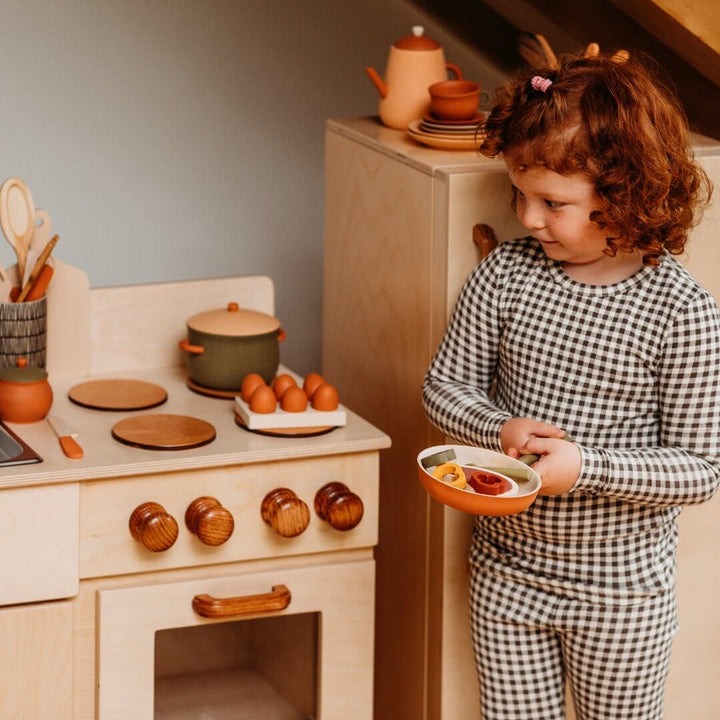 A child playing with the Classic Wooden Play Kitchen and Refridgerator Set