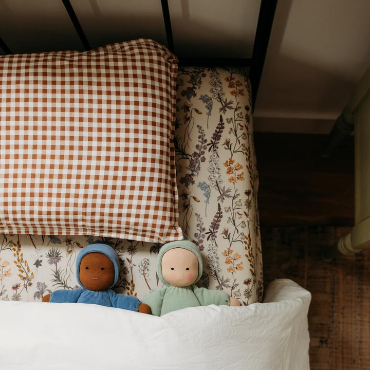 Two Bella Luna Toys Waldorf Dolls tucked into a child's bed.