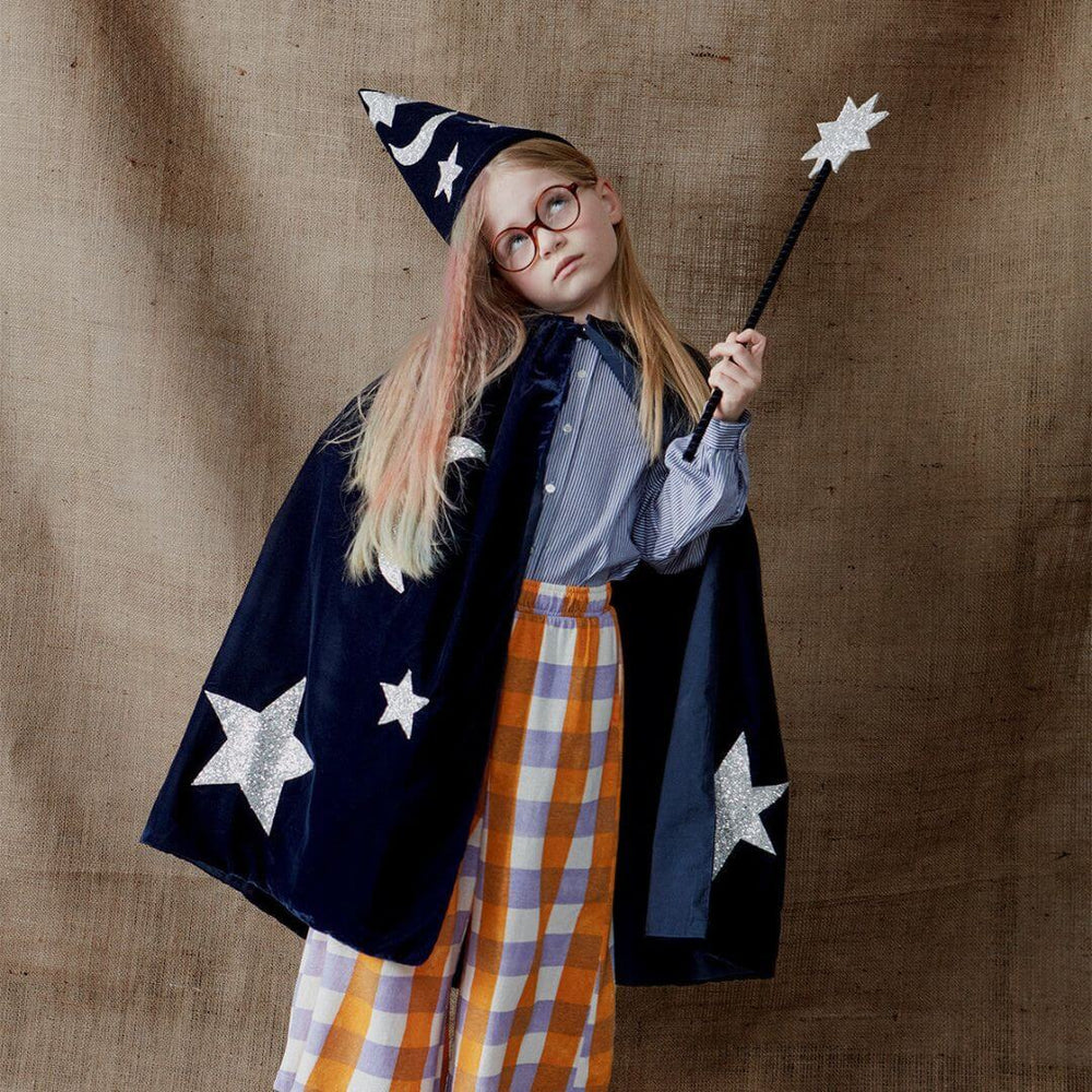 A child wearing the Blue Velvet Wizard costume and waving the silver star wand.