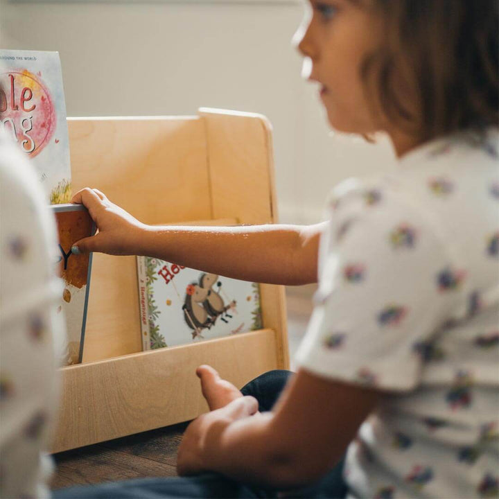 Child taking book out of Book Nook Wooden Book Shelf