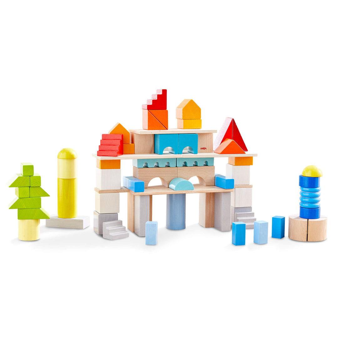 Colored Building Blocks 85 Piece Set with green, blues, red, orange, yellows, white, gray, and natural colored wooden building blocks stacked