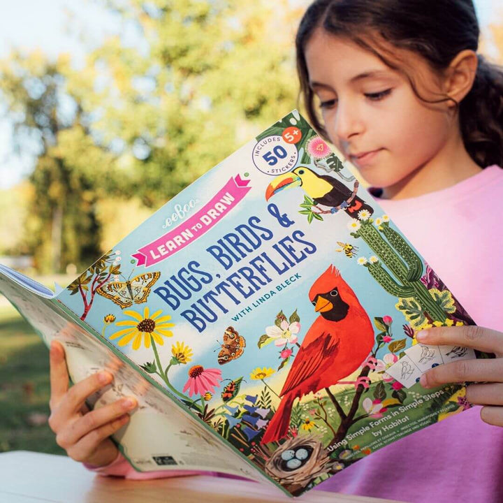 Young girl reading eeBoo’s Learn to Draw Birds and Butterflies book, featuring colorful illustrations, step-by-step drawing guides, and nature-themed designs for kids.