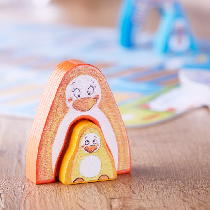 Close up of 2 orange wooden penguin game pieces