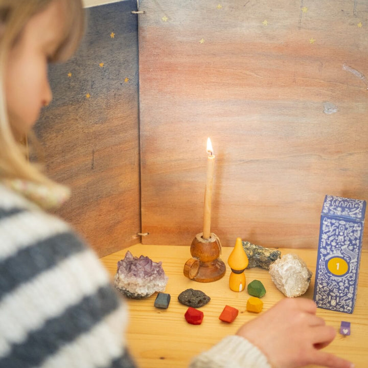 A child sets up their holiday advent display with parts from the 2024 Grapat Advent Calendar.