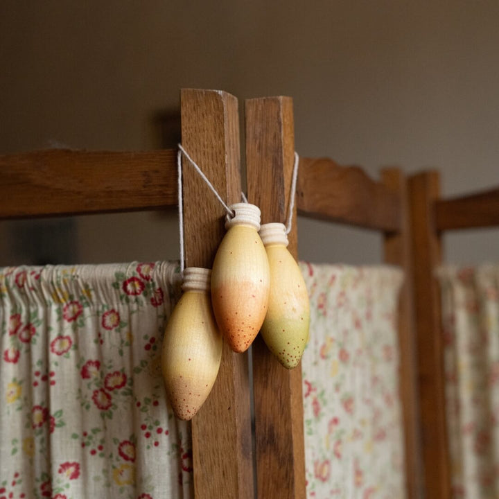 Grapat Glow Lamps wooden ornaments set hang on a piece of wooden furniture.