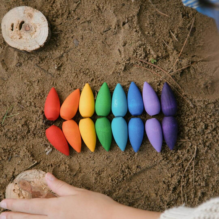 Grapat Mandala Rainbow Snowflakes in the sand with child's hand