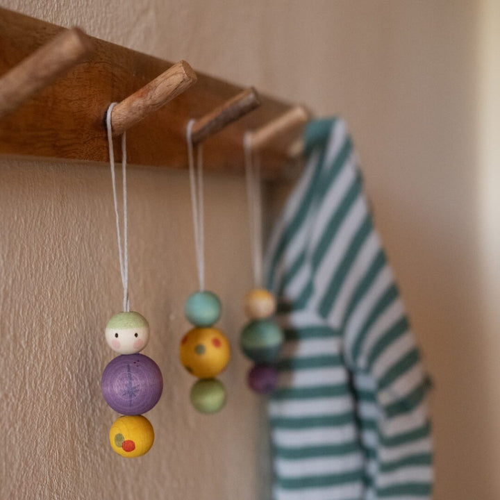 Grapat Snow Buddy Wooden Ornaments hanging on wooden pegs.