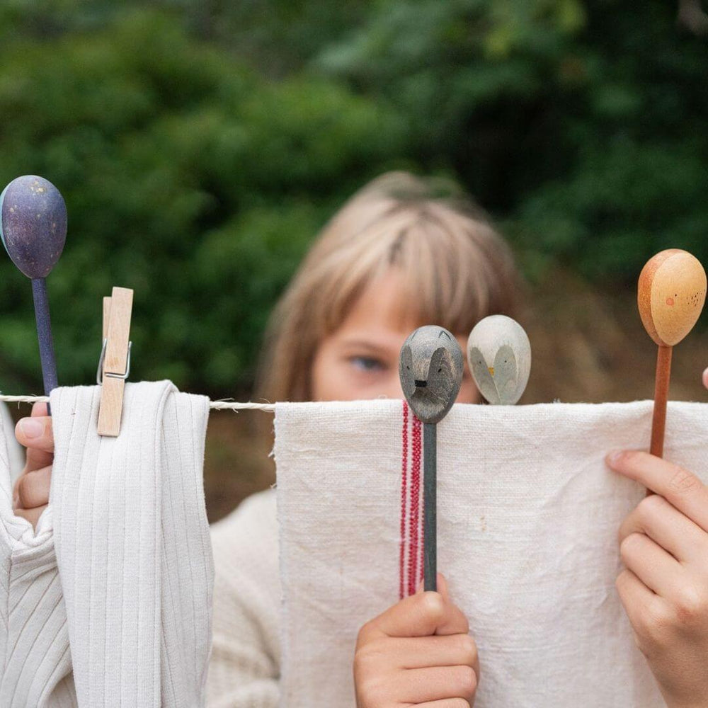 Young child having a puppet show with  Grapat Wooden Puppets. This child is using 4 of the wooden figures to inspire imaginative play and creativity.