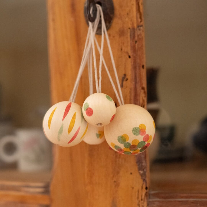 Grapat Wonder Balls wooden ornament set hanging from a metal key on a cupboard door.