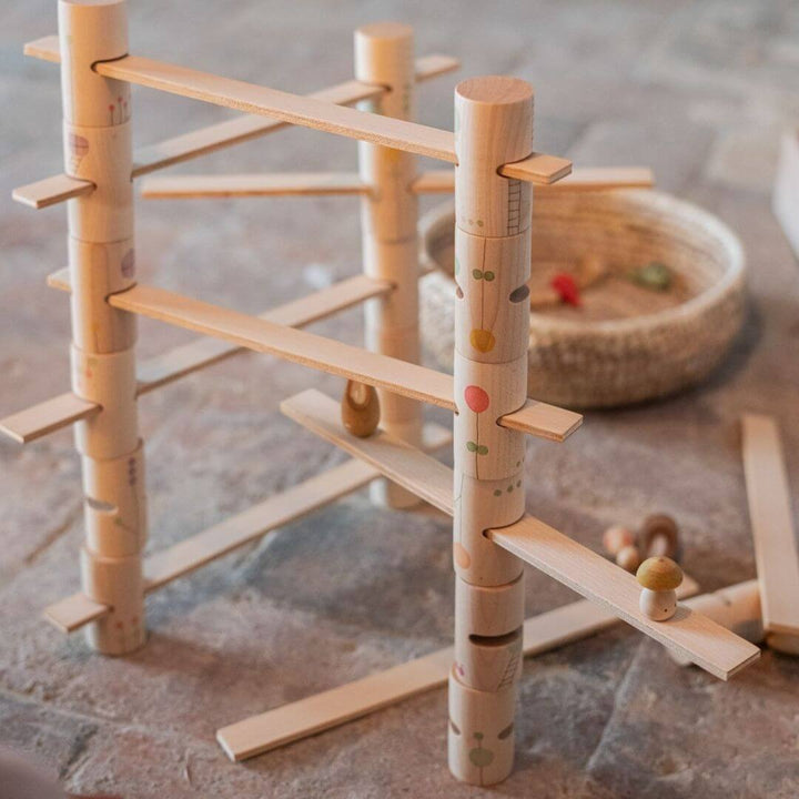 Grapat Woodland Stacking Tower Set with hand-painted wooden tubes and walkways, set up with other wooden toys for open-ended building and imaginative play.