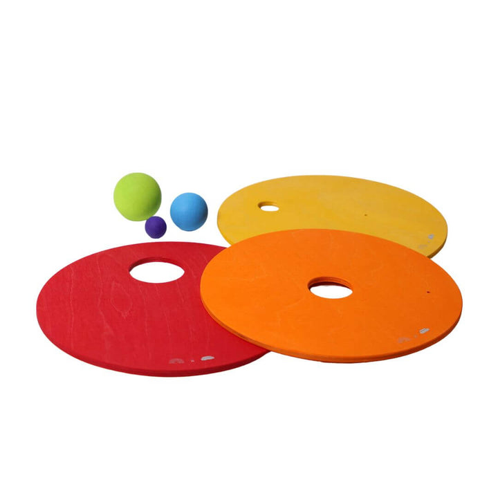 3 warm colored discs with 3 wooden balls from Grimm's Wooden Toys.