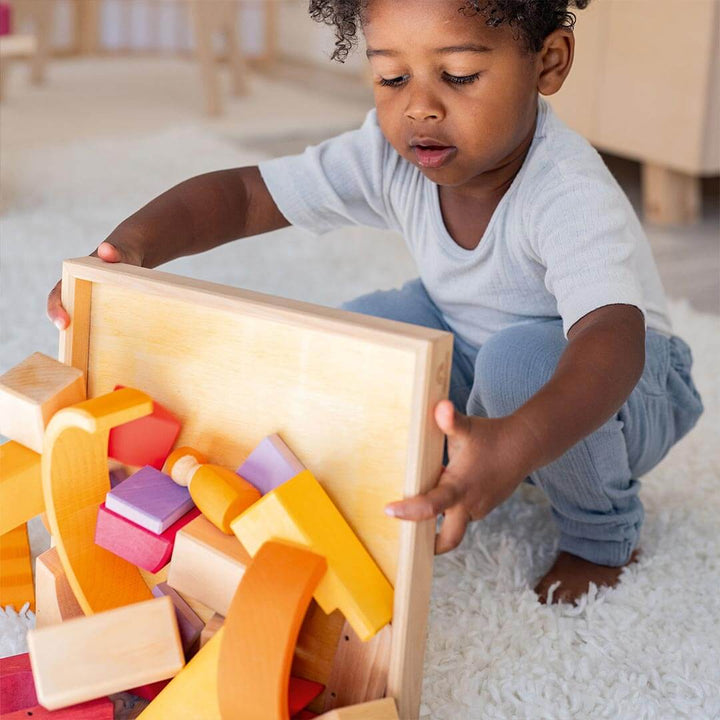 Child playing with Grimm's Wooden Building World Desert Sand