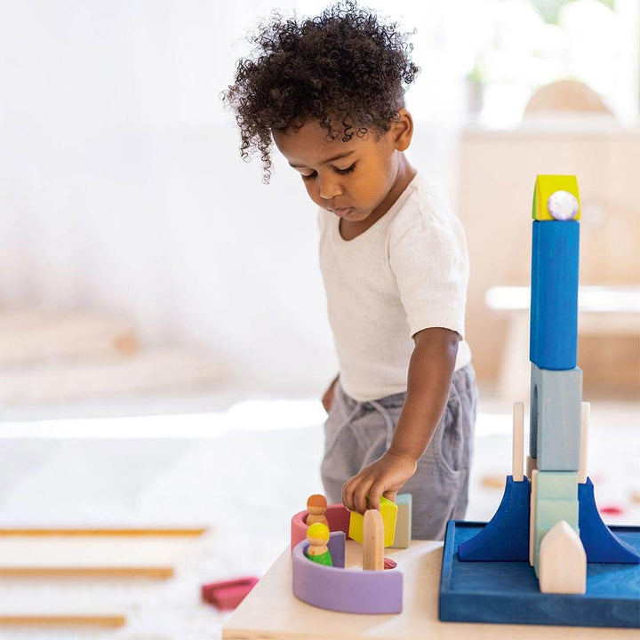 Child playing with Grimm's Wooden Building World Polar Light Set