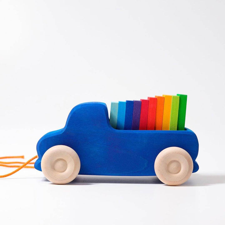 Grimm's Wooden Pull Along Truck - royal blue truck with natural wooden wheels and orange pull along string with 10 rainbow colored blocks in the truck bed - from the side