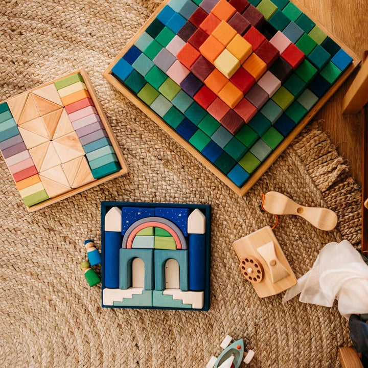 Grimm's Pastel Duo Wooden Block Set on a rug with other Grimm's blocks.