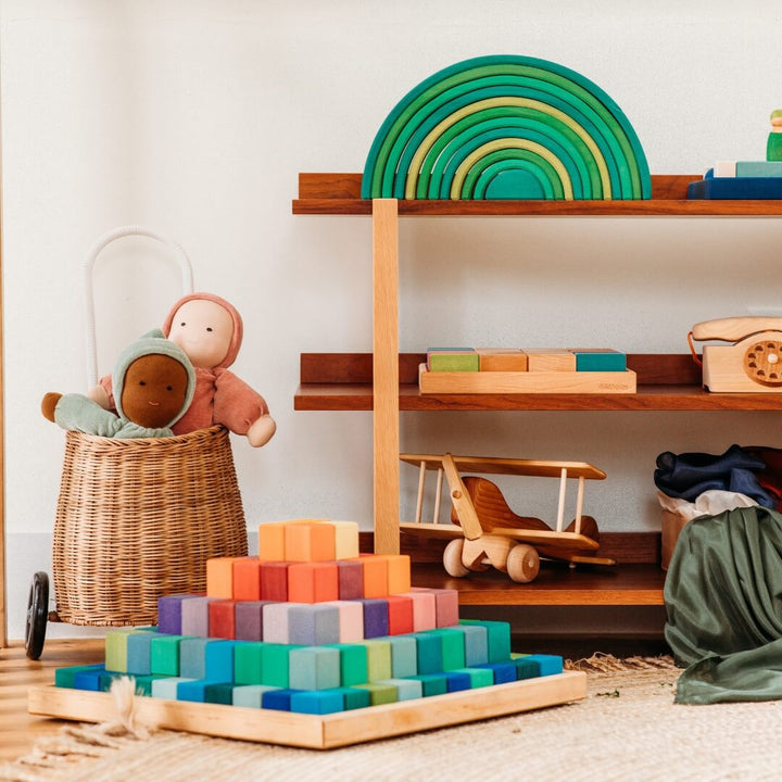 The Grimm's Large Stepped Pyramid next to a shelf in a playroom.