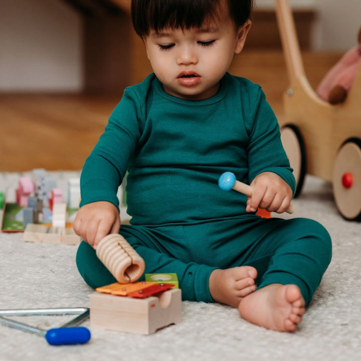 A child playing the bells from the HABA Musical Joy play set.