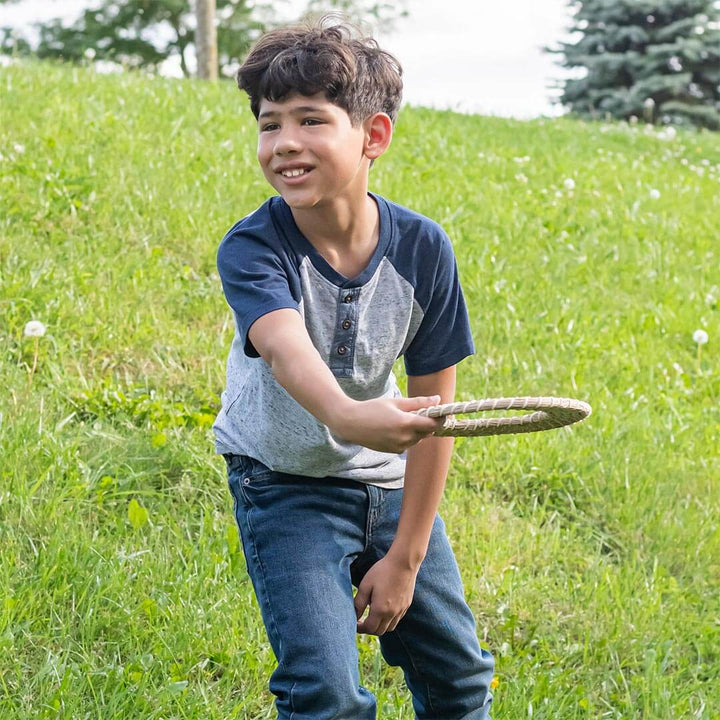 Boy in a field throwing the Huckleberry Seagrass Flying Disc