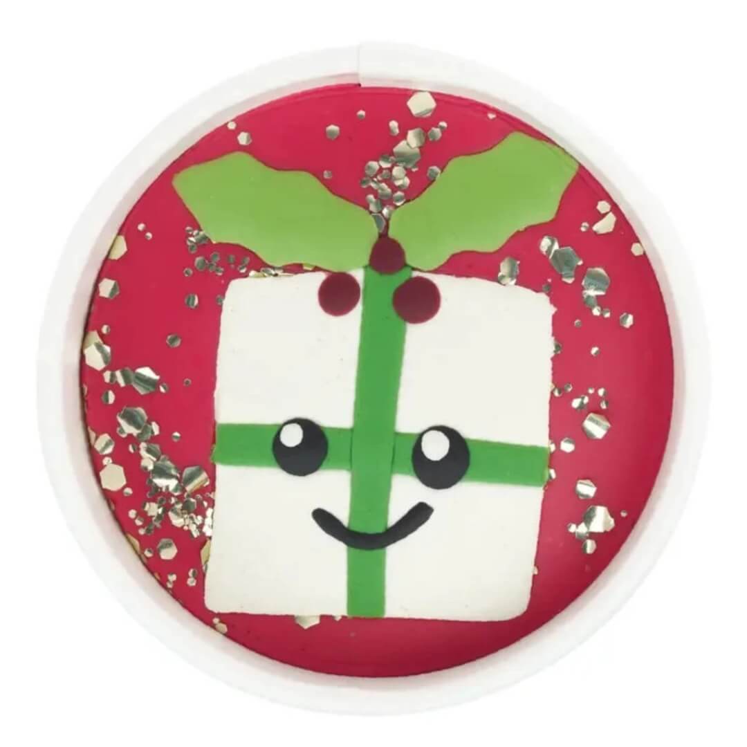 Land of Dough Pleasant Present Playdough Cup featuring a white present with green ribbon and holly decorations.