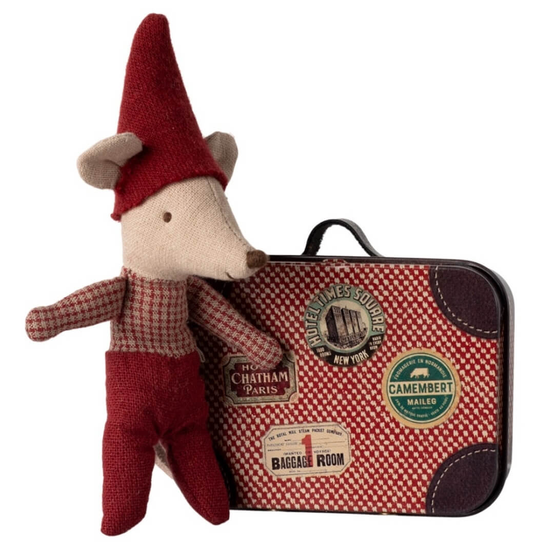 A baby Maileg mouse with a pointy red cap, red pants and plaid shirt next to a red plaid suitcase.