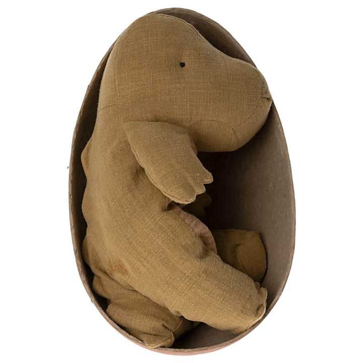 A charming Maileg plush Gantosaurus in a warm ocher hue, sitting inside its egg, perfect for play and display