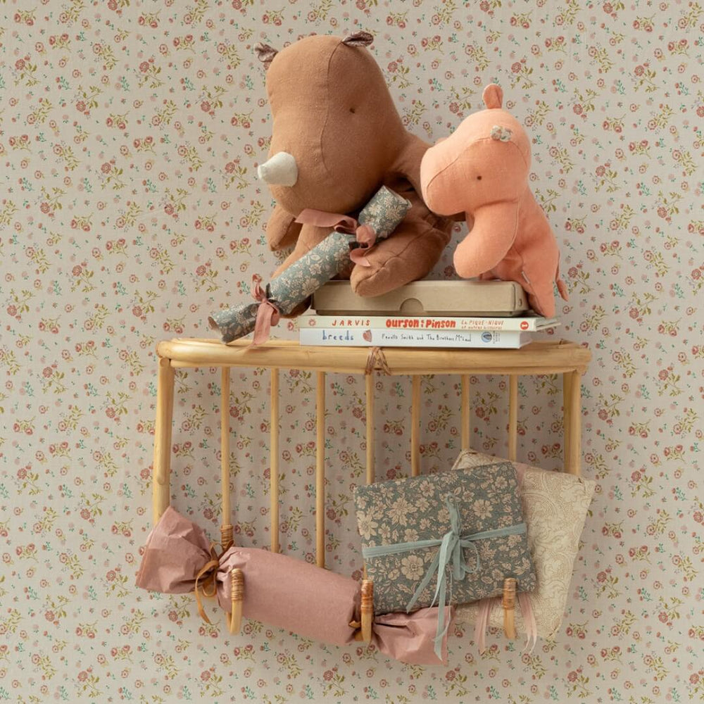 Maileg chocolate medium sized rhino stuffed animal on a shelf with a smaller hippo and books.