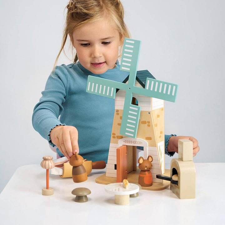 Child holding wooden bear figure and playing with Tender Leaf Toys Wooden Penny Windmill play set