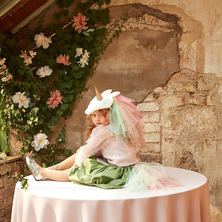 A child dressed up for imaginary play in the tulle 2 piece Rainbow Unicorn Costume