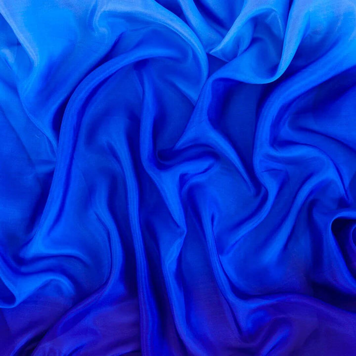 A light blue to royal blue ombre printed silk scarf aranged and filling the whole image.