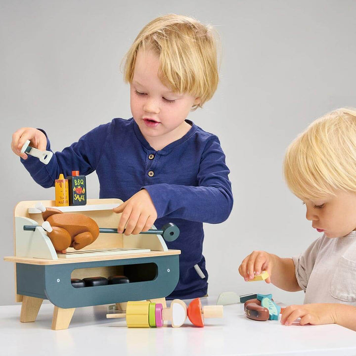 Two children playing with Tender Leaf Toys Wooden Barbeque Play Set