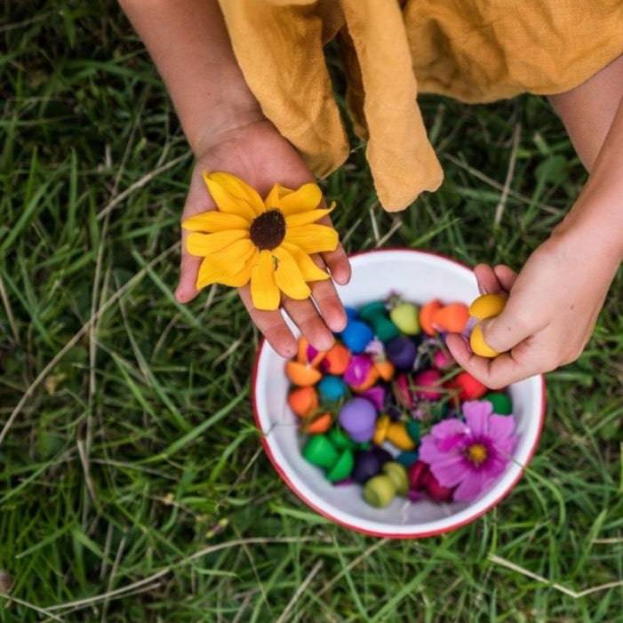 Child playing outside with bowl of Grapat Mandala Wooden Rainbow Mushrooms