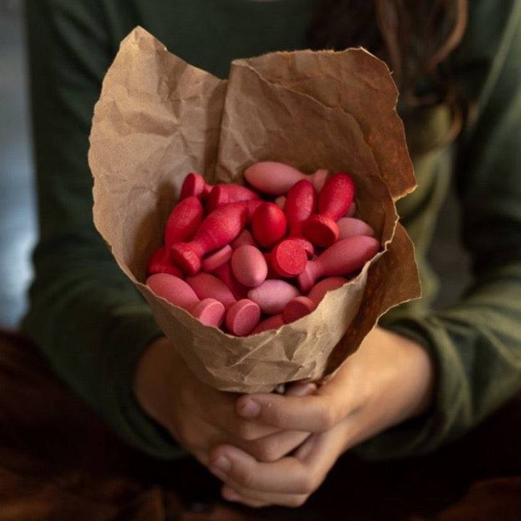 Child holding a "boquet" of craft paper and a collection of Grapat Wooden Mandala Flower Petals